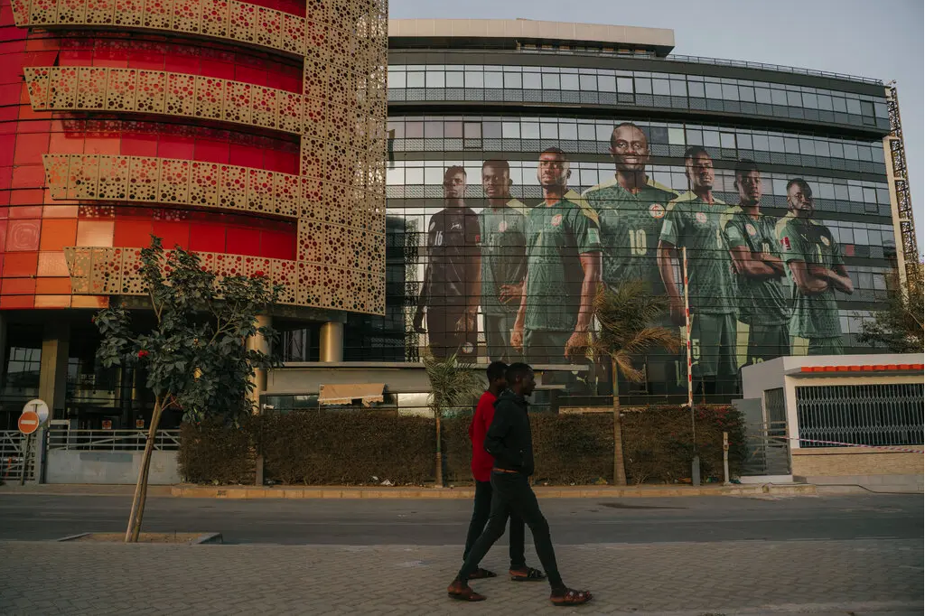 Une photo de l'équipe nationale sénégalaise décorant la façade d'un immeuble à Dakar. Crédit... Carmen Abd Ali pour le New York Times 